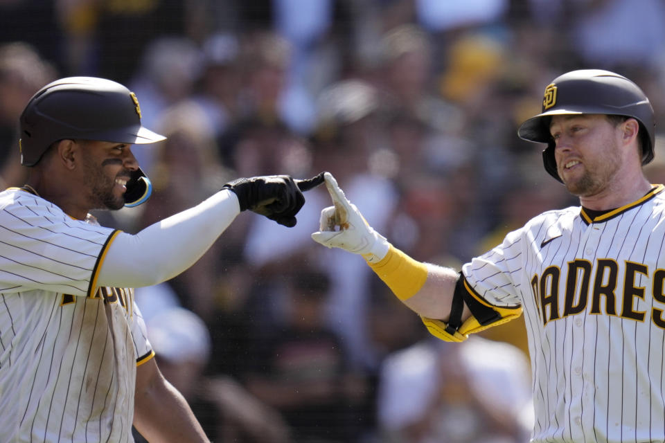 San Diego Padres' Jake Cronenworth, right, celebrates with teammate Xander Bogaerts after hitting a two-run home run during the seventh inning of a baseball game against the Milwaukee Brewers, Saturday, April 15, 2023, in San Diego. (AP Photo/Gregory Bull)