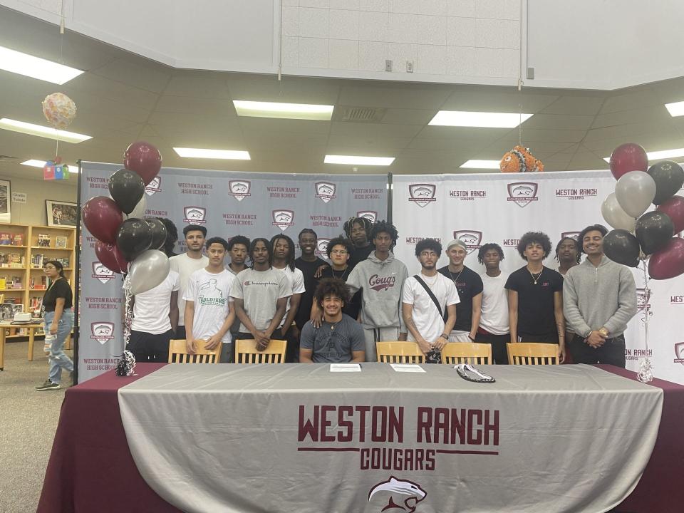 Khristian Holmes (center) and the Weston Ranch boys basketball team pose for a pitcher at Holmes signing day.