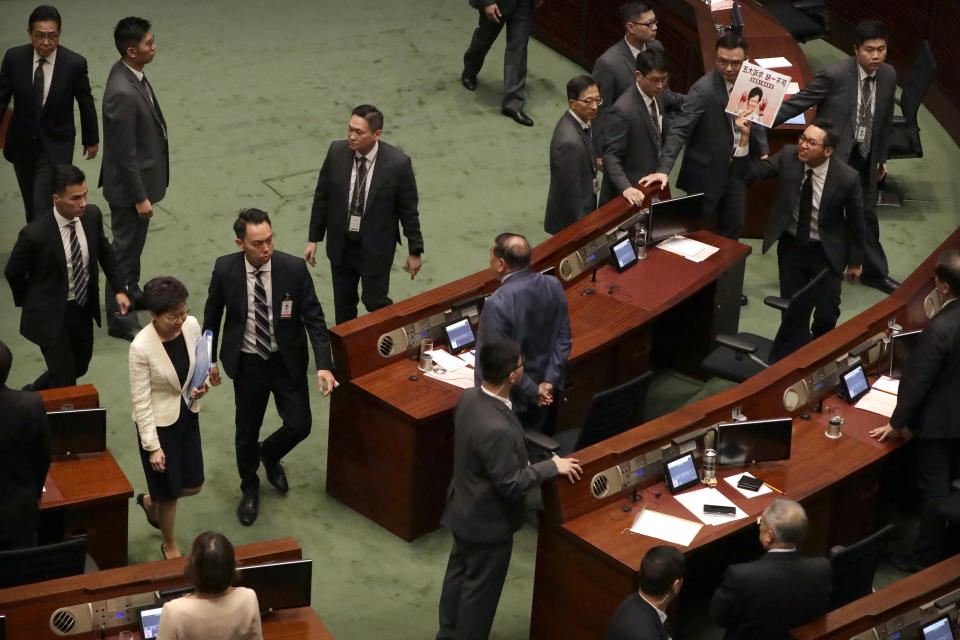 A pro-democracy lawmaker, top right, jeers as Hong Kong Chief Executive Carrie Lam, left, leaves a question and answer session at the Legislative Council in Hong Kong, Thursday, Oct. 17, 2019. (AP Photo/Mark Schiefelbein)