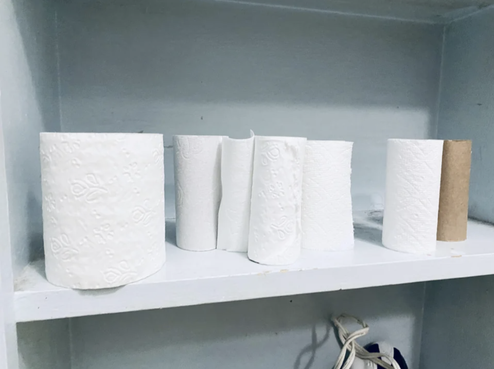 Instead of using one roll of toilet paper until it's gone, there are several partially used rolls stacked next to each other
