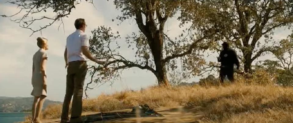 Zodiac killer in front of oak trees pointing a weapon at two victims in the film