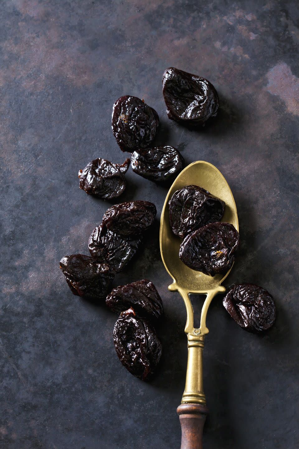 prunes on a vintage brass spoon