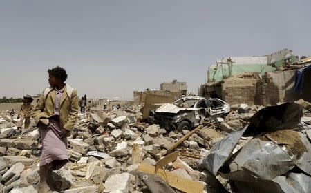 A boy walks at the site of a Saudi-led air strike that hit a residential area last month near Sanaa airport, May 18, 2015. REUTERS/Khaled Abdullah