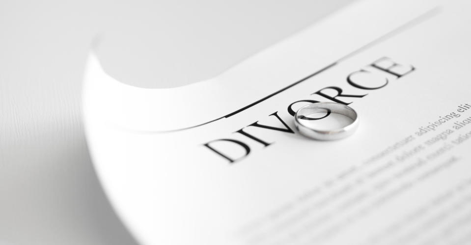 Divorce papers with a wedding band on top