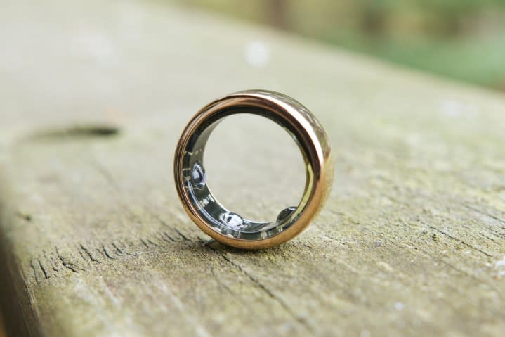 Oura Ring Horizon sitting upright on a wood railing.