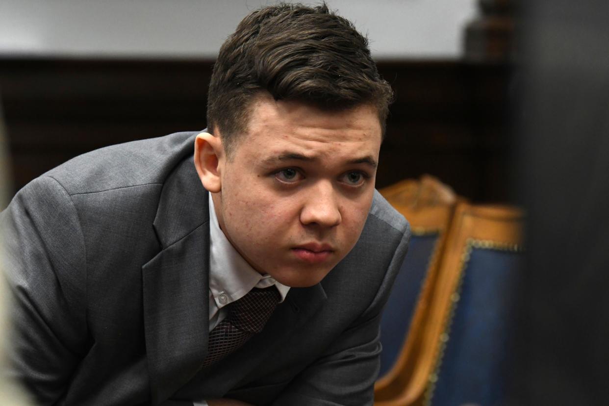 Kyle Rittenhouse peers at the screen as attorneys for both sides argue about a video during Rittenhouse's trial at the Kenosha County Courthouse on Friday