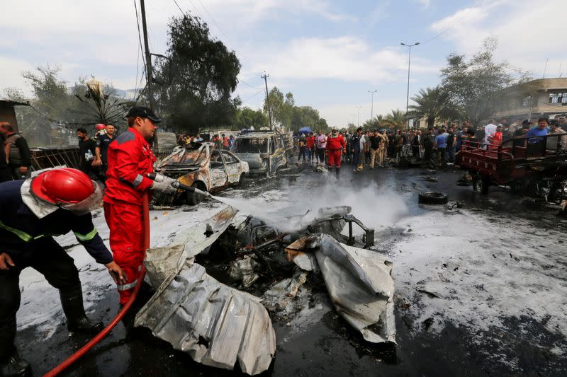 Firefighters inspect the site of a car bomb attack in Sadr City district of Baghdad