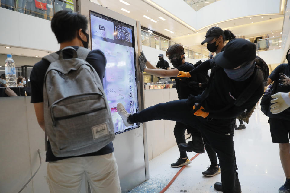 Protesters damage an electronic display board in a mall in Hong Kong on Sunday, Sept. 22, 2019. Protesters smashed surveillance cameras and electronic ticket sensors in a subway station, as pro-democracy demonstrations took a violent turn once again. (AP Photo/Kin Cheung)