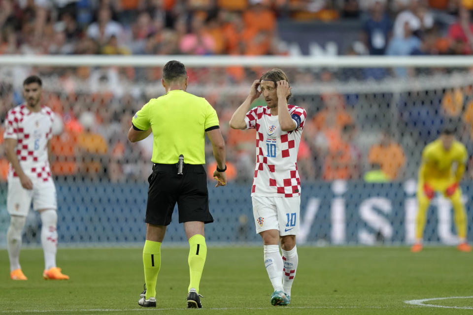 Croatia's Luka Modric talks to Referee Istvan Kovacs during the Nations League semifinal soccer match between the Netherlands and Croatia at De Kuip stadium in Rotterdam, Netherlands, Wednesday, June 14, 2023. (AP Photo/Peter Dejong)