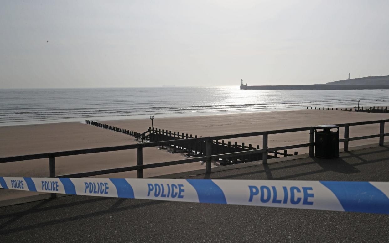 A police cordon in place on Aberdeen beach where two people were pulled from the sea by the RNLI and taken to hospital where they died - PA