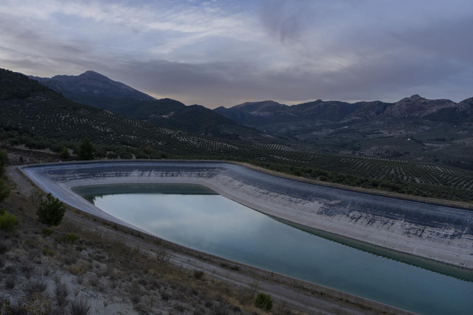 A pond is filled with water from the Arteson river and used by local olive farmers in the southern town of Quesada, a rural community in the heartland of Spain's olive country, Saturday, Oct. 29, 2022. Spain, the world’s leading olive producer, has seen its harvest this year fall victim to the global weather shifts fueled by climate change. An extremely hot and dry summer that has shrunk reservoirs and sparked forest fires is now threatening the heartiest of its staple crops. (AP Photo/Bernat Armangue)