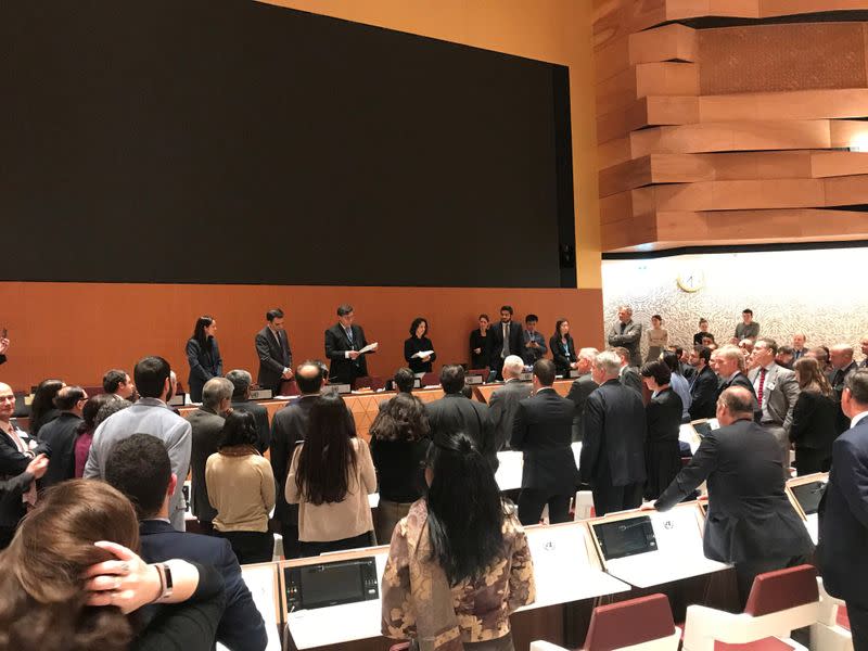 Delegates gather around an empty screen at a meeting on lethal autonomous weapons in the United Nations in Geneva