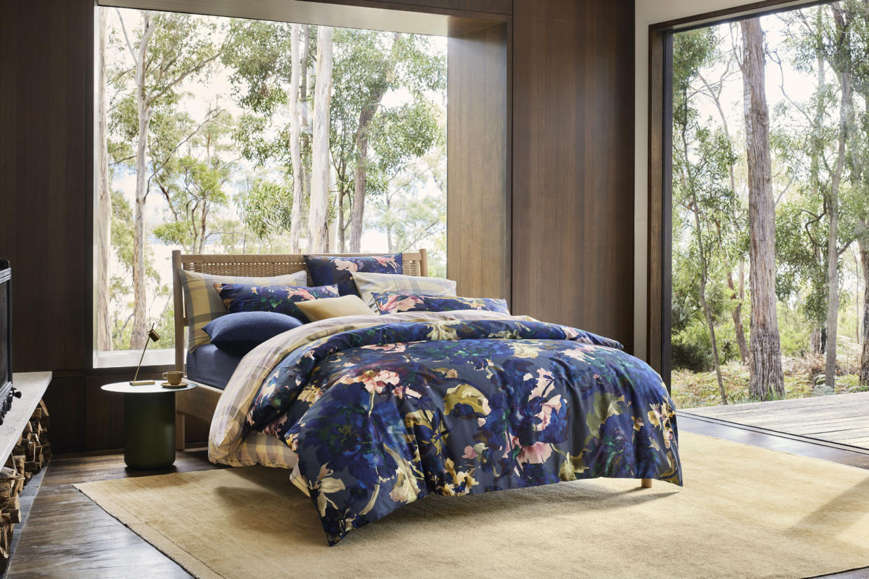  A dark blue patterned bedset on a bed. 