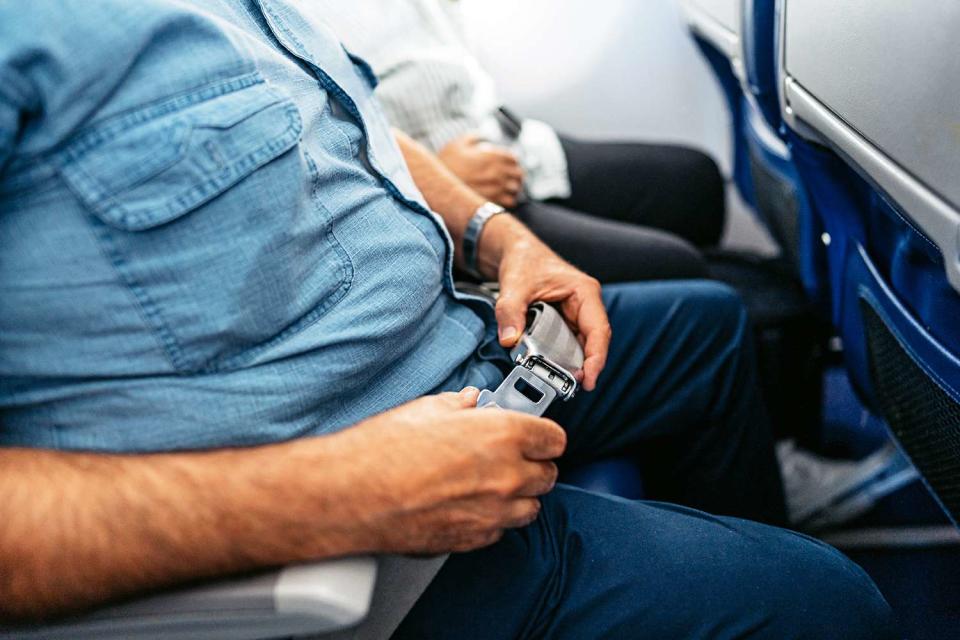 <p>Getty</p> Middle seat passenger using both armrests 