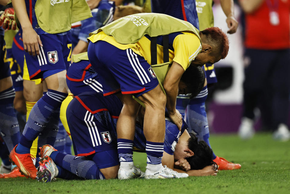 Soccer Football - FIFA World Cup Qatar 2022 - Round of 16 - Japan v Croatia - Al Janoub Stadium, Al Wakrah, Qatar - December 5, 2022  Japan's Yuto Nagatomo looks dejected with teammates after the penalty shootout as Japan are eliminated from the World Cup REUTERS/Hamad I Mohammed