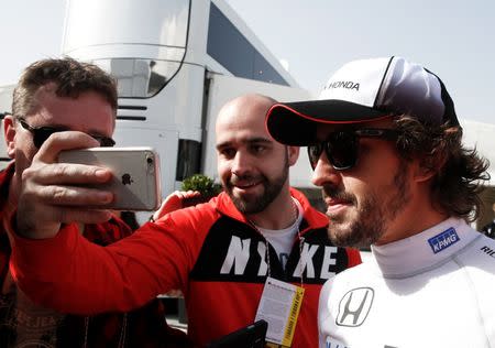 McLaren Formula One driver Fernando Alonso of Spain poses for a selfie with a supporter during the second testing session ahead of the upcoming season at the Circuit Barcelona-Catalunya in Montmelo, Spain, February 23, 2016. REUTERS/Sergio Perez