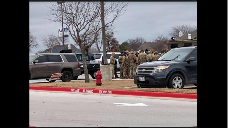 Members of a SWAT team wait instructions in the parking lot of Colleyville Middle School near the Congregation Beth Israel in Colleyville. A man held hostages in the Colleyville synagogue.