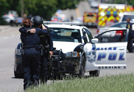 Dallas police officers hug after police responded to a shooting incident in Dallas, Texas, U.S. May 1, 2017. REUTERS/Brandon Wade