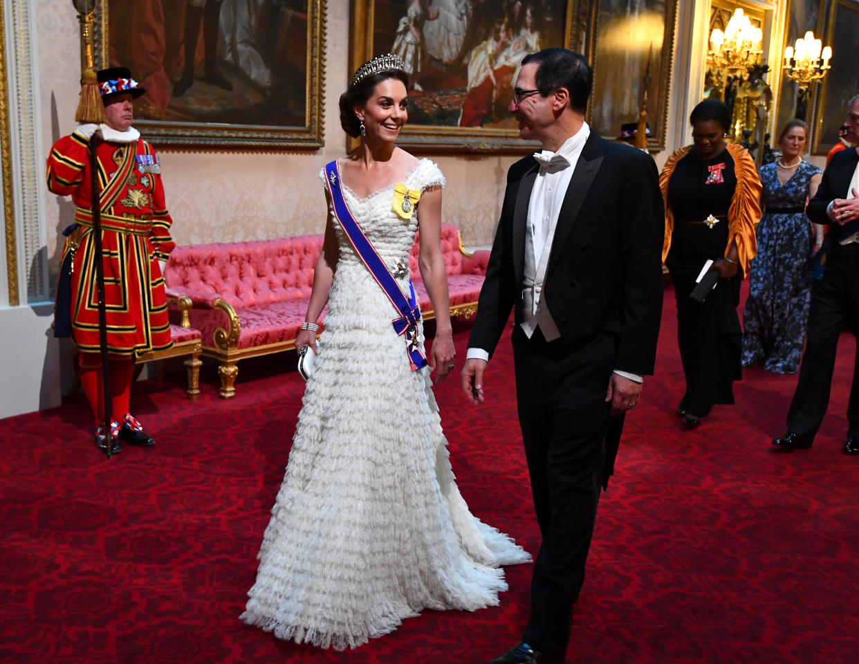 The Duchess of Cambridge and United States Secretary of the Treasury, Steven Mnuchin arrive through the East Gallery during the State Banquet at Buckingham Palace, London, on day one of the US President's three day state visit to the UK.