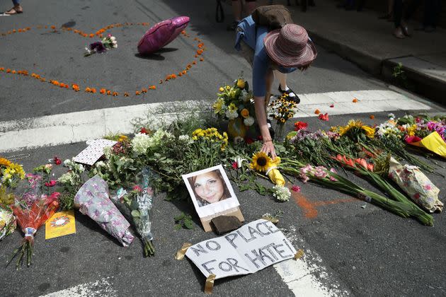 A woman places flowers at an informal memorial to 32-year-old Heather Heyer on Aug. 13, 2017. Heyer was killed when a car plowed into a crowd of people protesting the white supremacist Unite the Right rally, in Charlottesville, Virginia. (Photo: Chip Somodevilla via Getty Images)