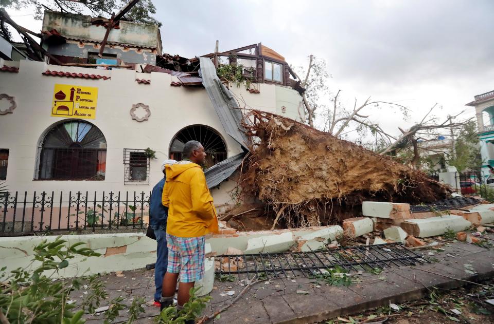 AME4766. LA HABANA (CUBA), 28/01/2019.- Vecinos observan los daños causados a una vivienda tras el paso de un tornado, este lunes, en La Habana (Cuba). Al menos tres personas han muerto y 172 han resultado heridas por un tornado que azotó esta madrugada la barriada de Regla, en La Habana, informó hoy el presidente de Cuba, Miguel Díaz-Canel. EFE/Ernesto Mastrascusa