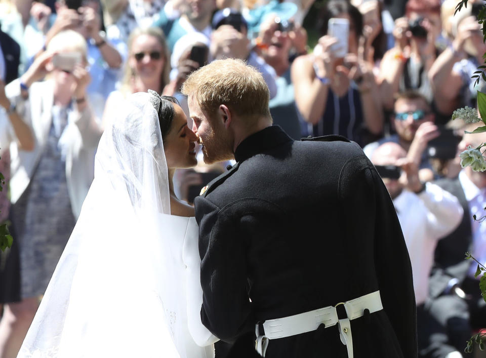 Prince Harry and Meghan Markle kiss on the steps of St George’s Chapel. Source: AAP