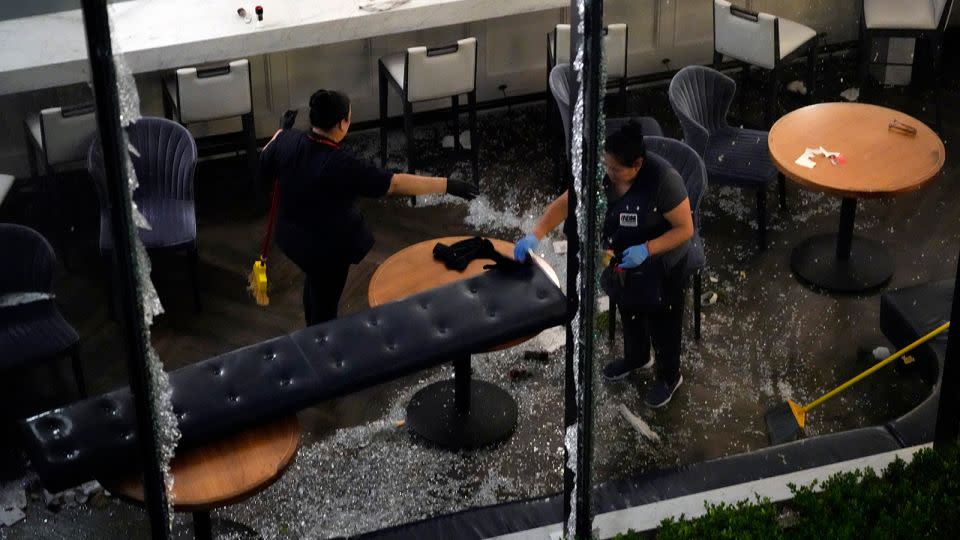 Workers clean up broken glass inside a damaged downtown restaurant after a severe thunderstorm Thursday in Houston. - David J. Phillip/AP