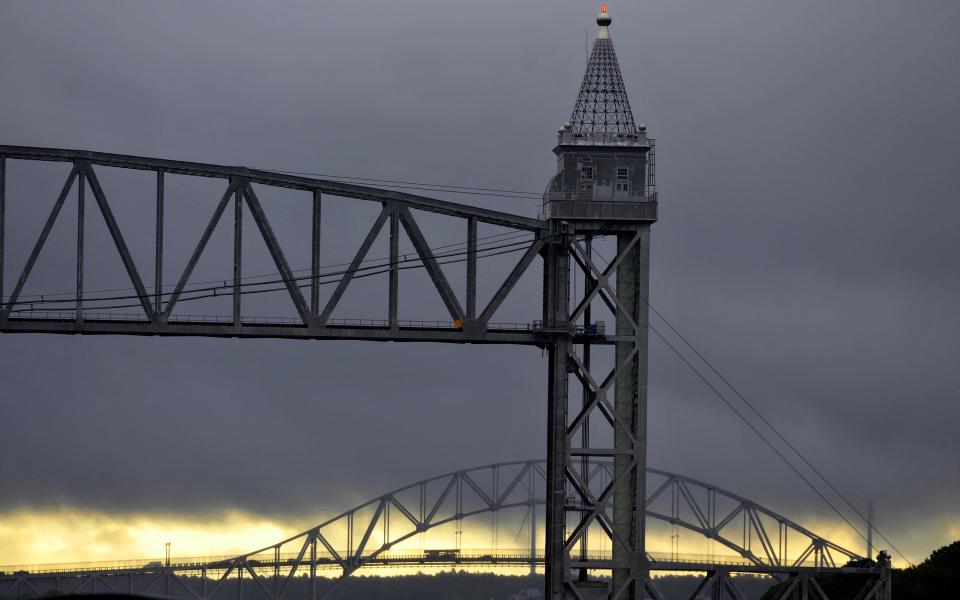 The rising sun set the eastern sky aglow as a heavy band of showers moved over the Cape Cod Canal bridges on an August morning in Buzzards Bay. Steve Heaslip/Cape Cod Times