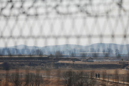 North Korean soldiers patrol behind a border fence near the North Korean town of Sinuiju and Dandong in China's Liaoning province, March 31, 2017. REUTERS/Damir Sagolj