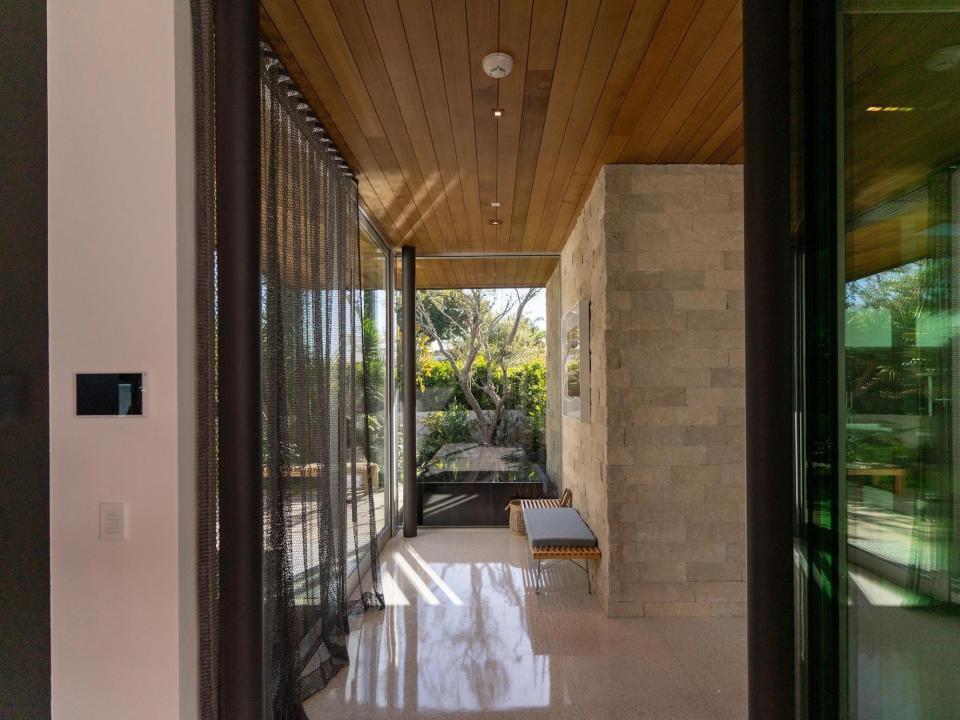 A hallway with marble floors and glass walls.