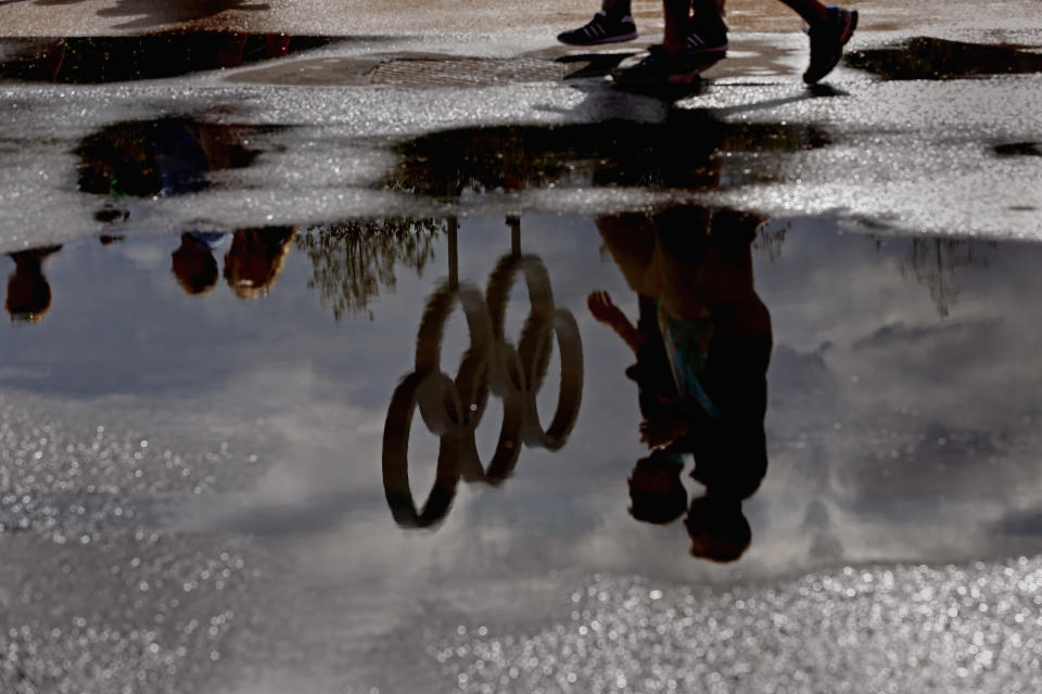 LONDON, ENGLAND - JULY 29: The Olympic Rings are reflected in a puddle in the Olympic Park on Day 2 of the London 2012 Olympic Games on July 29, 2012 in London, England. (Photo by Jeff J Mitchell/Getty Images)