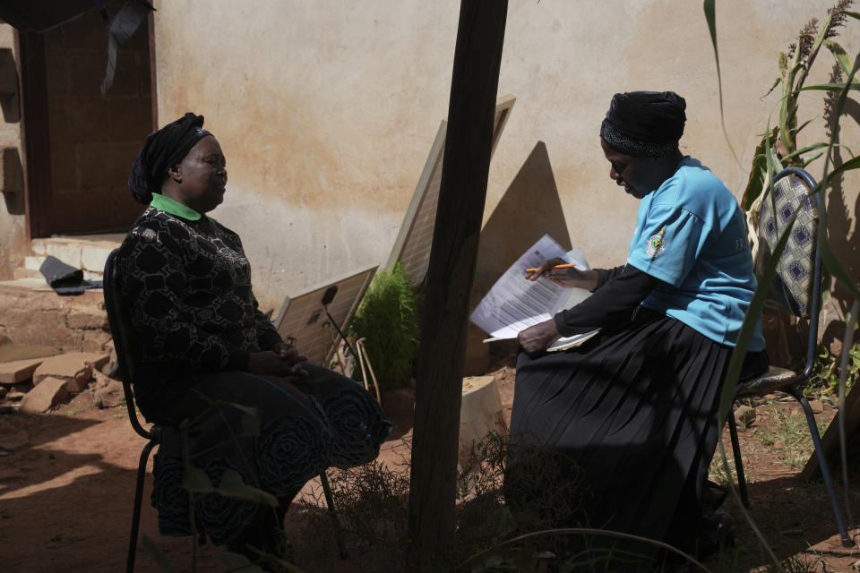 Siridzayi Dzukwa, a grandmother, right, talks to Tambudzai Tembo outside her house in Hatfcliffe on the outskirts of the capital Harare, Zimbabwe, Wednesday, May 15, 2024. In Zimbabwe, talk therapy involving park benches and a network of grandmothers has become a saving grace for people with mental health issues. Now the concept is being adopted in parts of the United States and elsewhere. (AP Photo/Tsvangirayi Mukwazhi)