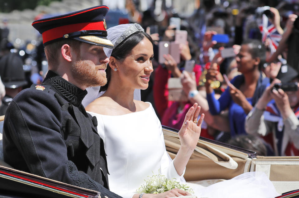 En esta foto del 19 de mayo del 2018, el príncipe Enrique y su flamante esposa, Meghan Markle, dan un paseo a carroza tras la ceremonia de su boda en la Capilla de San Jorge, en el Castillo de Windsor, cerca de Londres. El Palacio de Kensington anunció el lunes 15 de octubre del 2018, que Enrique y Meghan, duquesa de Sussex, esperan su primer bebé para la primavera boreal del 2019. (AP Foto/Frank Augstein, Archivo)