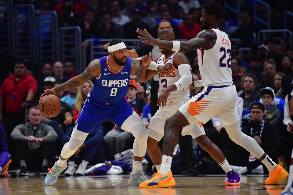 Oct 23, 2022; Los Angeles, California, USA; Los Angeles Clippers forward Marcus Morris Sr. (8) moves the ball against Phoenix Suns guard Chris Paul (3) and center Deandre Ayton (22) during the first half at Crypto.com Arena. Mandatory Credit: Gary A. Vasquez-USA TODAY Sports