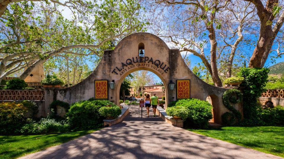 The entrance to the Tlaquepaque Arts and Crafts Village with vintage adobe style architecture and a popular tourist destination filled with retail shops and restaurants.