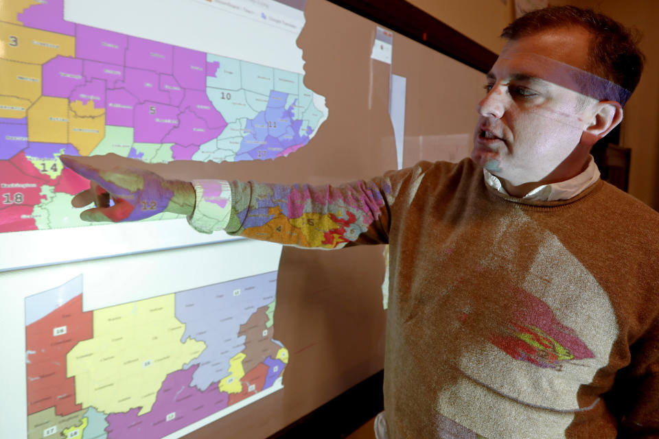 William Marx, points to projected images of the old congressional districts of Pennsylvania on top, and the new re-drawn districts on the bottom, while standing in the classroom where he teaches civics in Pittsburgh on Friday, Nov. 16, 2018. Marx was a plaintiff in the Pennsylvania lawsuit that successfully challenged the Republican-drawn congressional maps. Marx said he believes the new district boundaries resulted in "a more fair congressional representation of the will of the people in Pennsylvania." (AP Photo/Keith Srakocic)