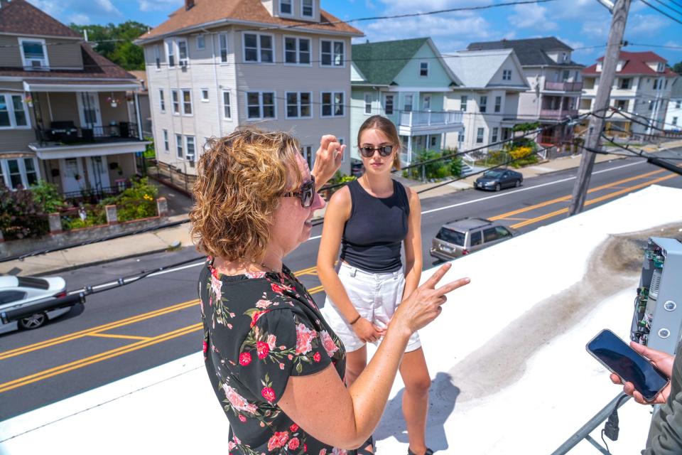Grace Berg, right, and Meredith Hastings of Brown University's Breathe Providence study explain the workings of an air monitor on Eddy Street. Breathe Providence is the only U.S. project to participate in a global effort to measure street-level pollution.