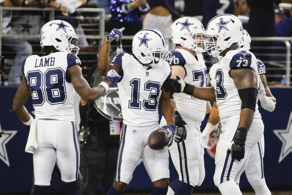 Dallas Cowboys wide receiver Michael Gallup (13) celebrates his first half touchdown with teammates CeeDee Lamb (88), Zack Martin (70), Tyler Smith (73) and Tony Pollard (20) during an NFL football game against the Philadelphia Eagles, Sunday, Dec. 10, 2023, in Arlington, Texas. (AP Photo/Michael Ainsworth)