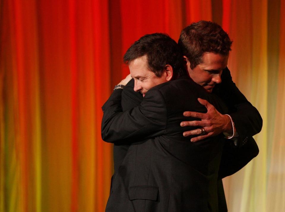 PHOTO: In this Nov. 5, 2008, file photo, actors Michael J. Fox and Ryan Reynolds embrace at the 'A Funny Thing Happened on the Way to Cure Parkinsons' benefit for the Michael J. Fox Foundation, at the Sheraton New York Hotel and Towers, in New York. (Stephen Lovekin/Getty Images, FILE)