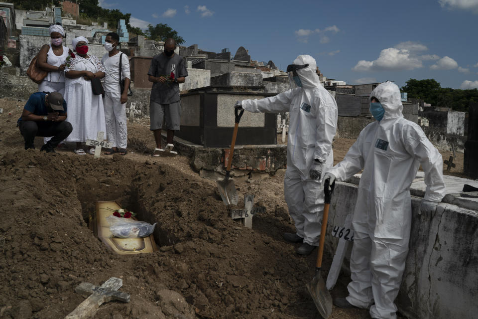 Taina dos Santos, third from left, attends the burial of her mother Ana Maria, a 56-year-old nursing assistant who died from the new coronavirus, in Rio de Janeiro, Brazil, Tuesday, April 28, 2020. Dos Santos said that the situation in the Salgado Filho public hospital where her mother worked is complicated and that some health workers have to buy their own protective gear. "She gave everything to her job until the very end," said the 27-year-old daughter. (AP Photo/Leo Correa)