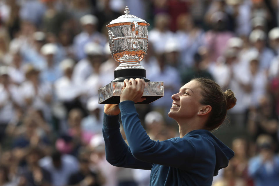 FILE - Romania's Simona Halep holds the trophy as she celebrates wining the final match of the French Open against Sloane Stephens of the U.S., at the Roland Garros stadium in Paris, France, Saturday, June 9, 2018. Two-time Grand Slam champion Simona Halep has been suspended from professional tennis for four years for alleged doping violations, the International Tennis Integrity Agency said Tuesday, Sept. 12, 2023. (AP Photo/Alessandra Tarantino, File)