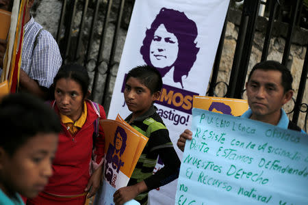 Demonstrators hold placards outside a court during the trial of the men charged with the murder of indigenous environmental activist Berta Caceres, in Tegucigalpa, Honduras November 29, 2018. REUTERS/Jorge Cabrera