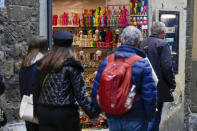 People walk past a shop selling souvenirs of Michelangelo's 16th century statue of David, in downtown Florence, central Italy, Monday, March 18, 2024. Michelangelo’s David has been a towering figure in Italian culture since its completion in 1504. But curators worry the marble statue’s religious and political significance is being diminished by the thousands of refrigerator magnets and other souvenirs focusing on David’s genitalia. The Galleria dell’Accademia’s director has positioned herself as David’s defender and takes swift aim at those profiteering from his image. (AP Photo/Andrew Medichini)