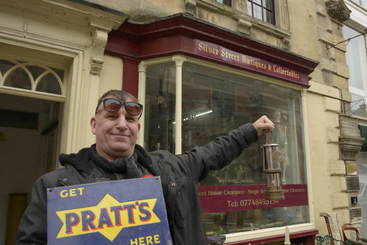 Roger Hearn at Silver Antiques with some of his latest items for sale: a miner's lamp and a classic enamel sign. <i>(Image: Trevor Porter 76878-1)</i>