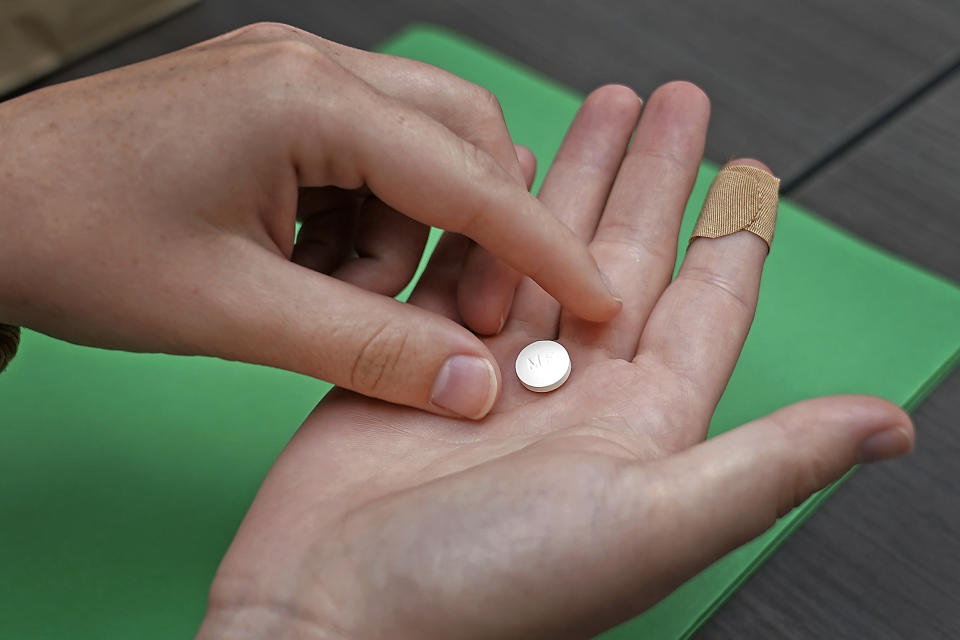 Haley Ruark prepares to take the first of two pills taken for a medical abortion during a visit to a Planned Parenthood clinic Wednesday, Oct. 12, 2022, in Kansas City, Kan. (AP Photo/Charlie Riedel)