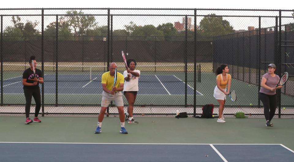 Jeff Collins puts Traci Jackson, Chene Woodard, Danielle Dabney and Maria Nederhood through drills at the Palmer Park courts in Detroit on Aug. 18, 2022. Collins is using teaching tennis as a way to celebrate his late wife of 36 years, Lois Collins.