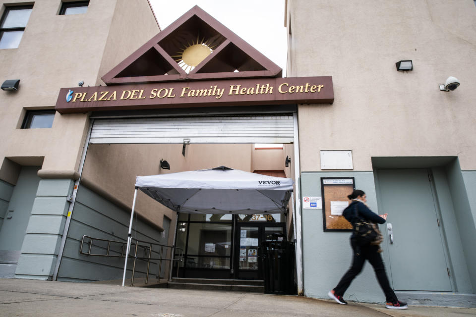 A woman exits the Plaza Del Sol Family Health Center in the Queens borough in New York, Thursday, Jan. 11, 2024. (AP Photo/Eduardo Munoz Alvarez)