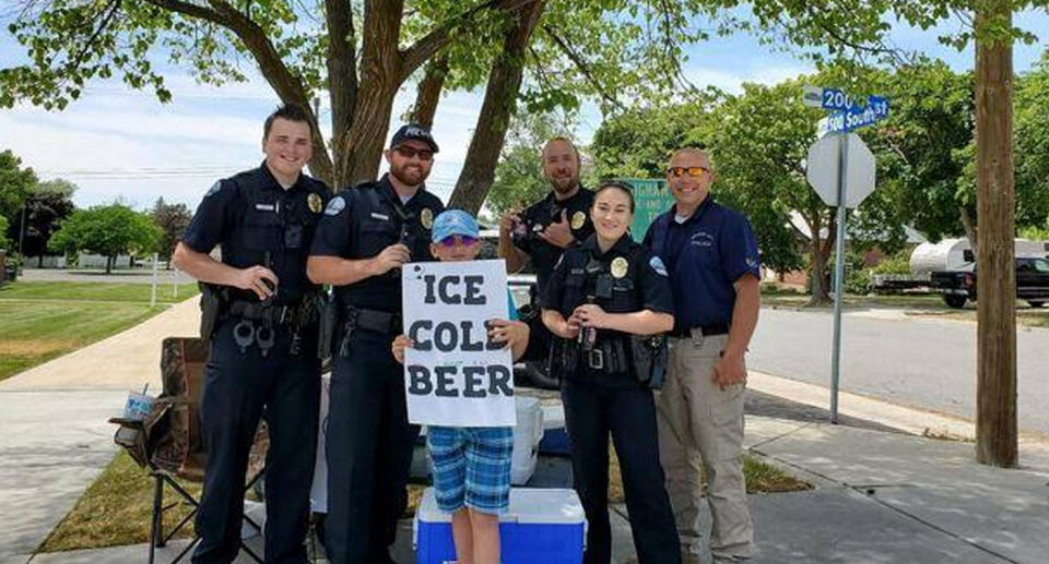 Photo of a young entrepreneur with local police who received reports he was selling beer on the street outside a church.