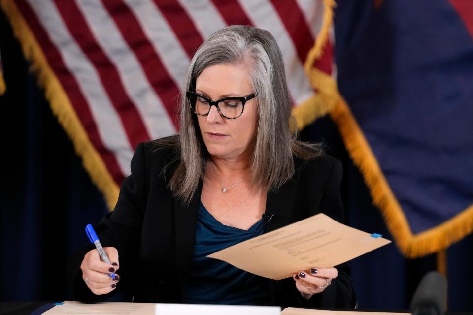 Katie Hobbs, the Democratic governor-elect and current secretary of state, signs the official certification for the Arizona general election canvass during a ceremony at the Arizona Capitol in Phoenix, Monday, Dec. 5, 2022.