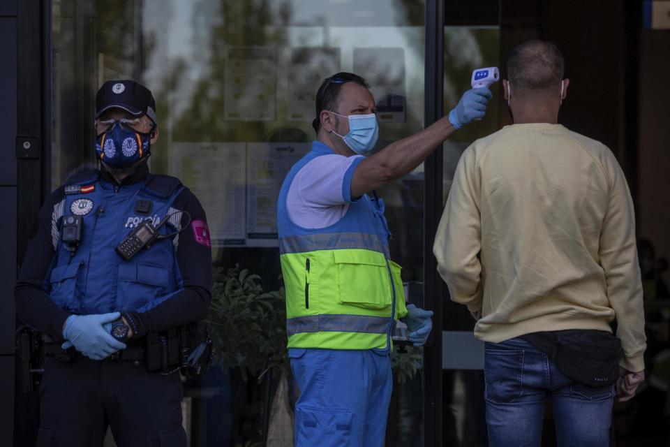 A health worker checks the temperature of a man ahead of a test for Covid-19 in Vallecas, Madrid (AP)